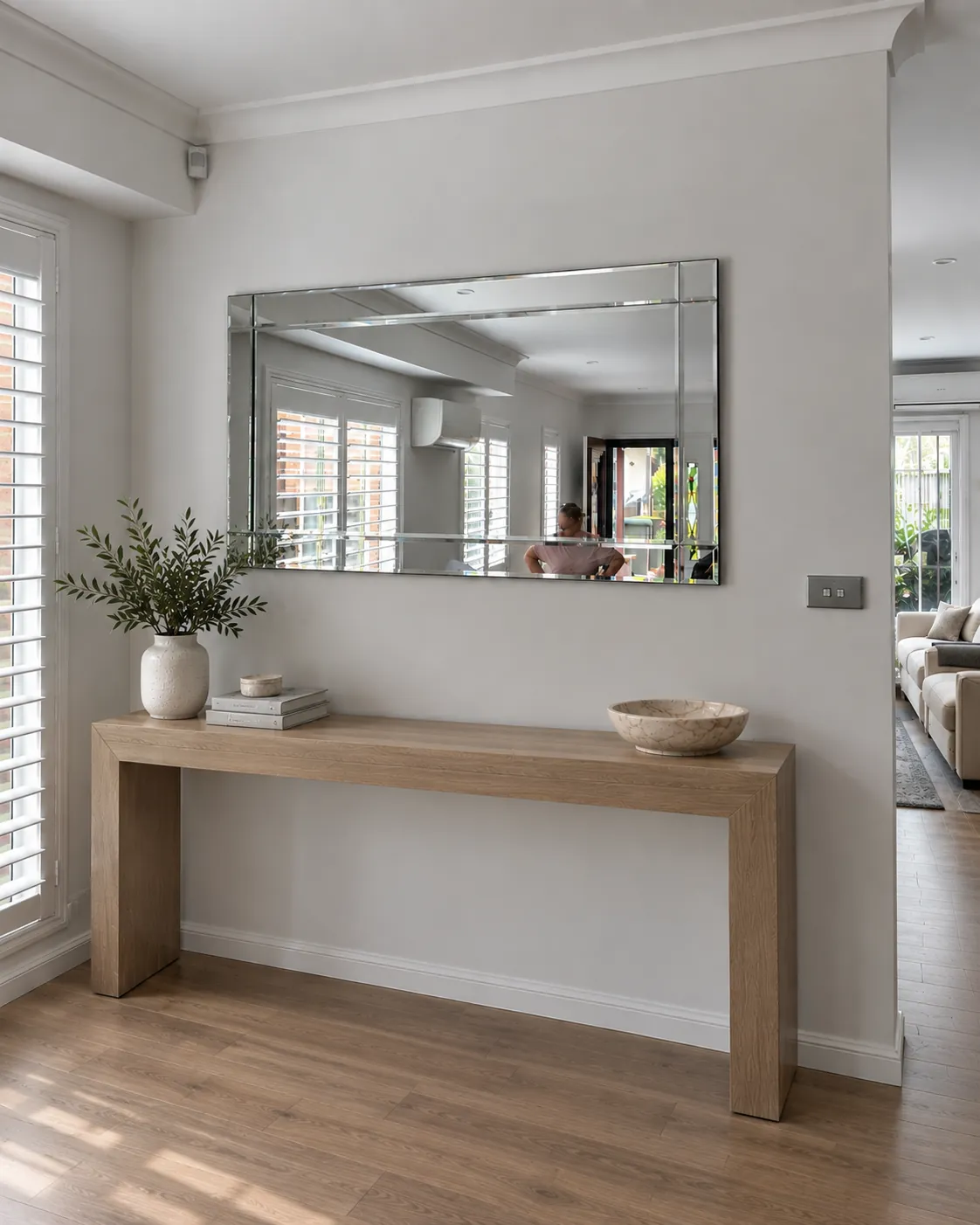 Wide bevelled mirror installed above a timber console