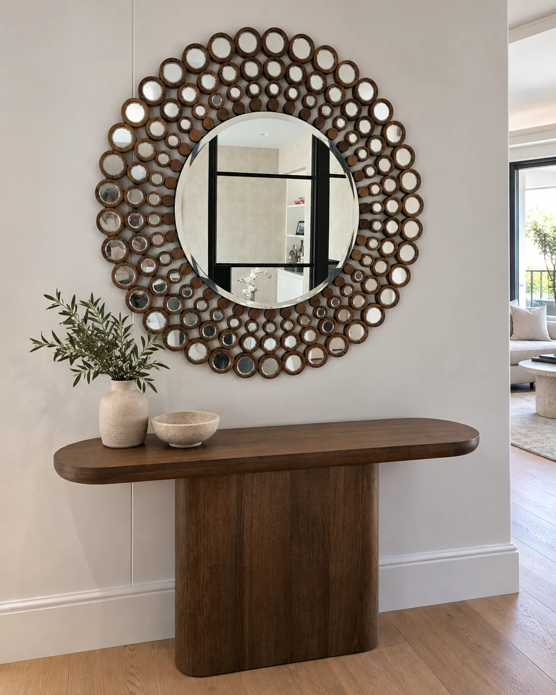 Large round timber-framed feature mirror installed above an entry console