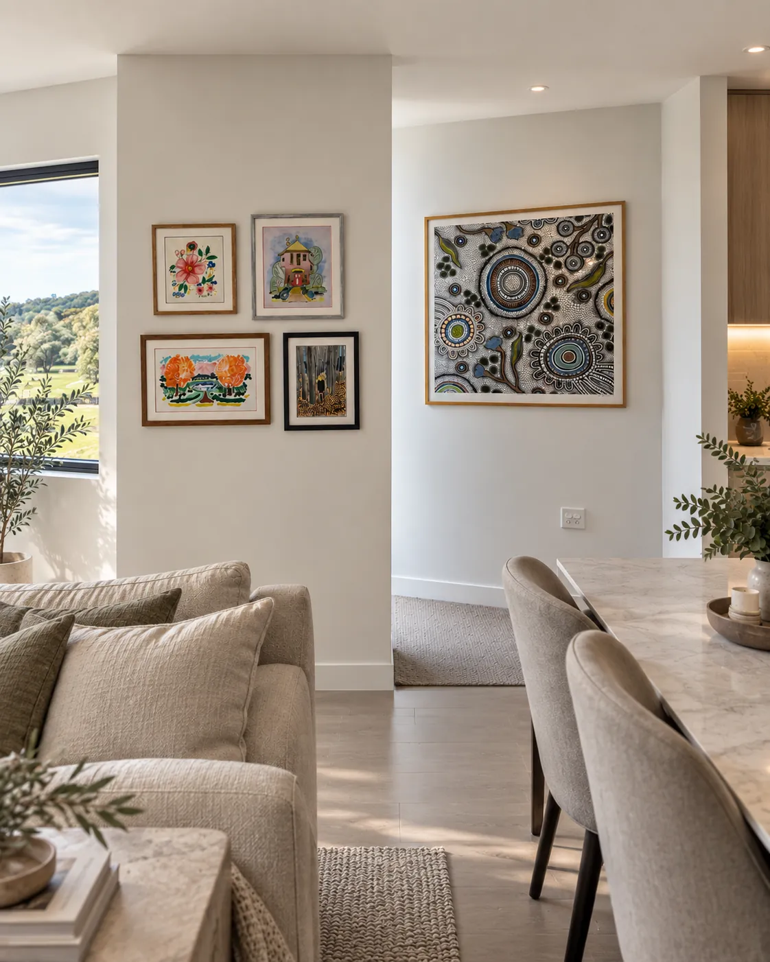 Four framed artworks grouped beside a larger framed piece in an open living space