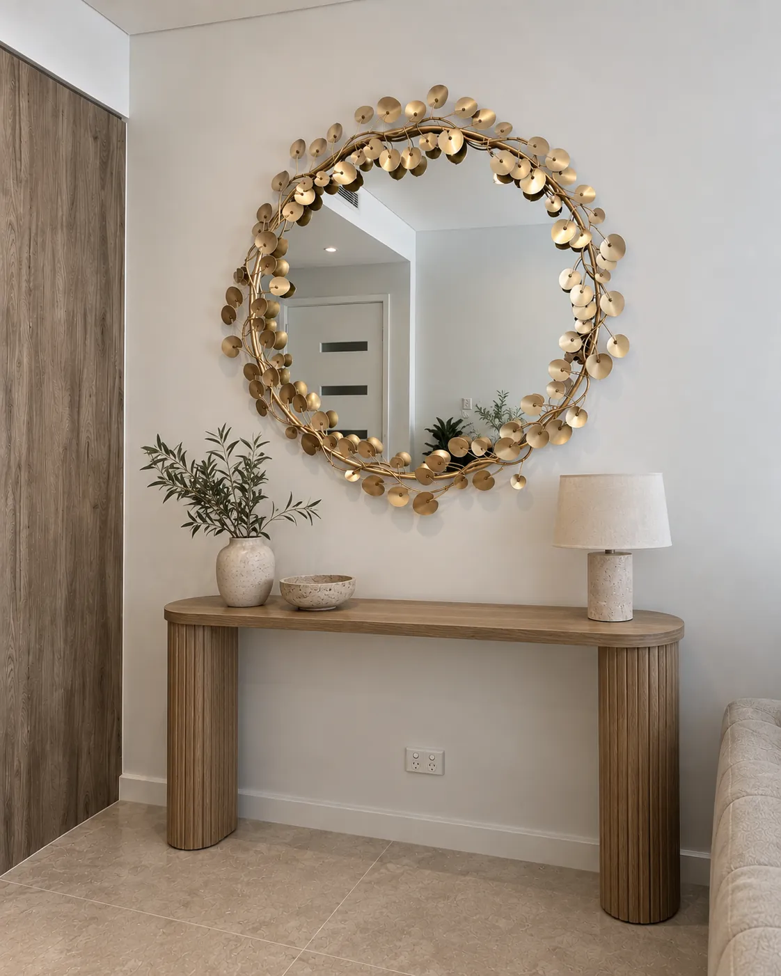Decorative brass mirror installed above a fluted console table